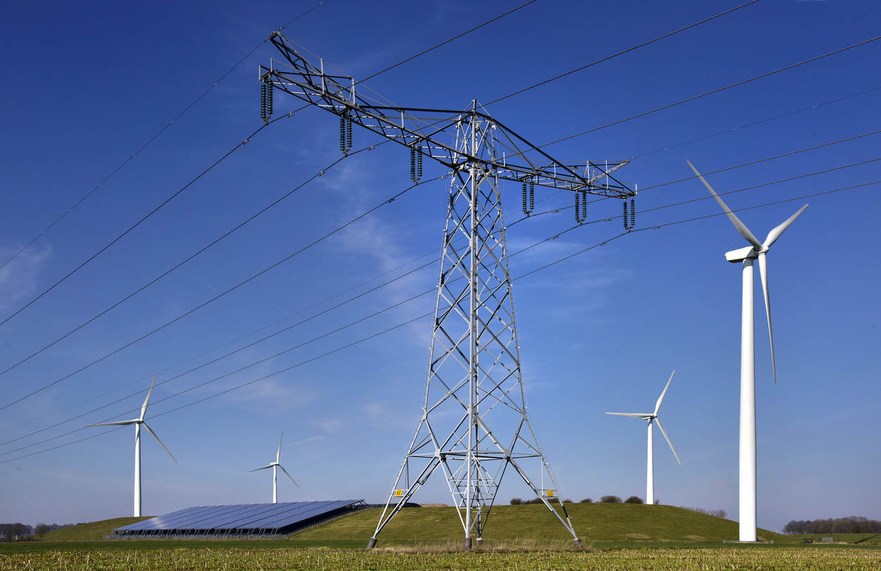 Afbeelding van een hoogspanningskabel, windturbine en zonnepanelen