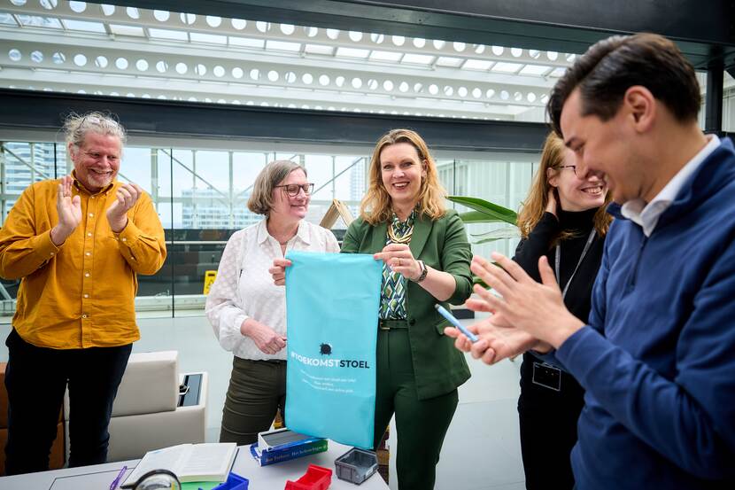 Sabien van der Leij houdt een lap waar 'Toekomststoel' op staat