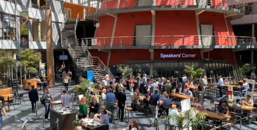 Overzicht van de grote hal van de Haagse Hogeschool. Hier werd op 22 juni 2022 het event Denk groot, doe klein en duurzaam gehouden. De dag was drukbezocht. Op de foto is een volle aula te zien.