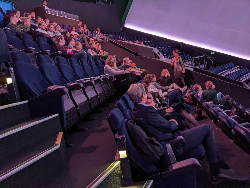 Bezoekers aan de Film Beyond Zero luisteren in de zaal van het Omniversum in Den Haag naar de openingsspeech van Charlotte Extercatte