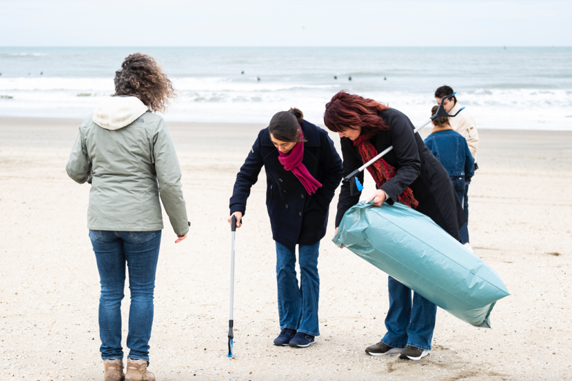 Strandjutten - pSG SZW Krista Kuipers (midden) zoekt zwerfafval met collega's van SZW op het strand van Scheveningen