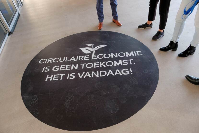 Een sticker op de grond met de tekst: "Circulaire economie is geen toekomst, het is vandaag"