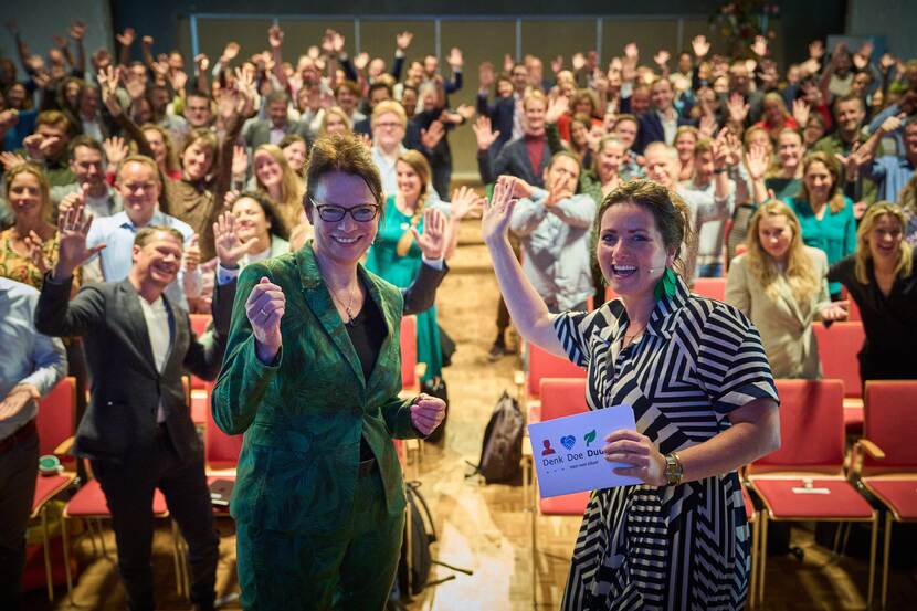 Sprekers en publiek op de achtergrond