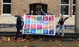 Het team van de provincie Zeeland met een vlag vol onderwerpen over duurzaam inkopen